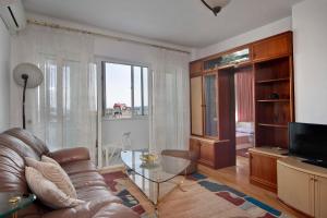 a living room with a leather couch and a television at Horizon Apartment in Varna City