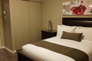 a bedroom with a large bed and a cabinet at Sweet 2-Bedroom Penthouse Apartment by Amazing Property Rentals in Gatineau