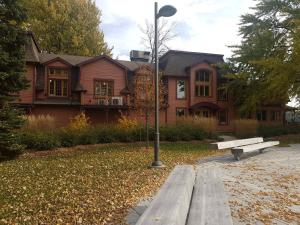 a house with a street light and a bench in front at Sweet 2-Bedroom Penthouse Apartment by Amazing Property Rentals in Gatineau