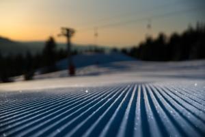 a snow covered ground with the sunset in the background at GudbrandsGard Hyttegrend Kvitfjell in Kvitfjell