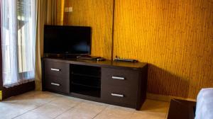 a entertainment center with a flat screen tv in a room at Leyeh Leyeh Homestay in Canggu +26 photos