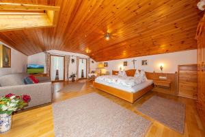 Habitación grande con cama y sofá en Gröbl-Alm Haus zur schönen Aussicht en Graswang