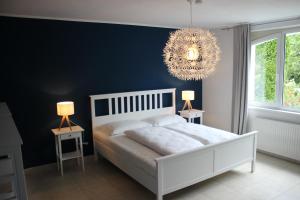 ボーデンスドルフにあるBlaues Haus Ferienwohnung Bodensdorf Ossiacher See Gerlitzen Alpeのベッドルーム1室(白いベッド1台、青い壁付)