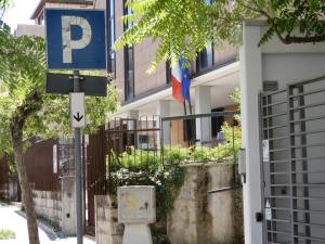 una señal de estacionamiento frente a un edificio con banderas en casa vacanze luciano&son, en Campobasso