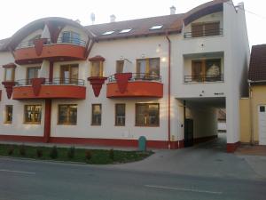 ハイドゥソボスローにあるCristian Apartmanの赤いバルコニー付きの白い大きな建物
