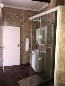 a bathroom with a shower and a glass door at Hill Top Farm Lodge in Sea Park