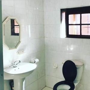 a bathroom with a sink and a toilet and a mirror at Hill Top Farm Lodge in Sea Park