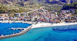eine Luftaufnahme eines Strandes mit Gebäuden und dem Meer in der Unterkunft Irida Apartments in Nea Skioni