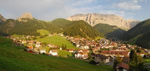 a small town on a hill with mountains in the background at Apartments Burvel in Selva