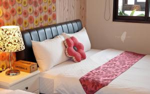 czerwone wypchane zwierzę siedzące na łóżku w obiekcie Fish House Hostel w mieście Wujie