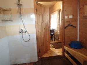 een douche in een houten badkamer met een bad bij Lomasaaret Cottages in Villala