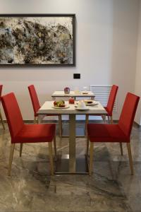 a table with red chairs and a plate of food on it at Hotel Principe di Lampedusa in Palermo