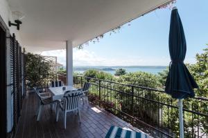 een balkon met een tafel en stoelen en een parasol bij Apartments SeaView in Portorož
