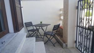 un piccolo tavolo con sedie sul balcone di Home of Fame - home gallery with fully equipped kitchen, separate entrance, free parking - IUN F3158 a Olbia