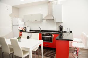 a kitchen with a white table and a red oven at Apartamentos Dacris in Jerte