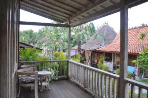 un balcone di una casa con tavolo e sedie di Kubudiuma Villas Bali a Canggu