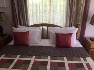 維多利亞的住宿－Mountain Top Chalet，一张带红色和白色枕头的床和窗户