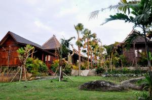 a row of houses in a resort with palm trees at Kubudiuma Villas Bali in Canggu