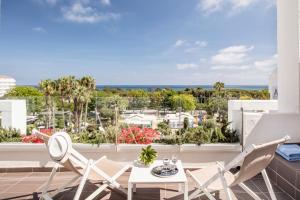 een balkon met een tafel en stoelen en uitzicht op de oceaan bij AQUA Hotel Aquamarina & Spa in Santa Susanna