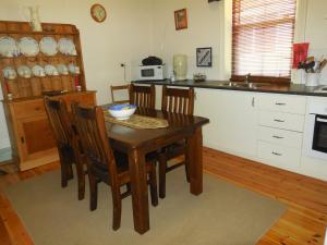 a kitchen with a wooden table with chairs and a sink at Amalie Cottage Waikerie Unit 1 in Waikerie