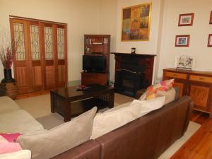 ein Wohnzimmer mit Couch und Kamin in der Unterkunft Amalie Cottage Waikerie Unit 1 in Waikerie