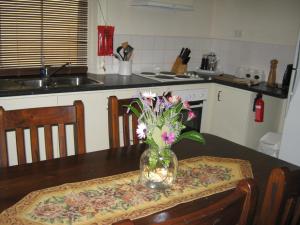 eine Vase mit Blumen auf dem Tisch in der Küche in der Unterkunft Amalie Cottage Waikerie Unit 1 in Waikerie + 4 Fotos