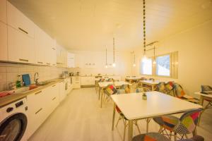 a large kitchen with tables and chairs in it at Capsule Hotel Ibedcity in Rovaniemi