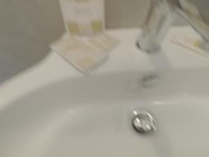 un lavandino bianco del bagno con aaucet e scarico di Le dimore di Magda 2 a Polignano a Mare