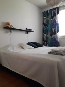 a bedroom with a white bed with a shelf on the wall at Apartment Kivistö, 2 km from centrum, free wifi and parking, no smoking, non-allergenic in Jyväskylä