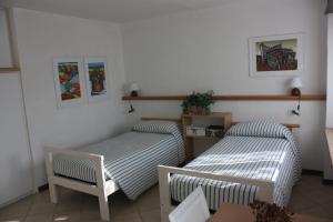 um quarto com duas camas e uma cadeira em B&B Brixius em Verona