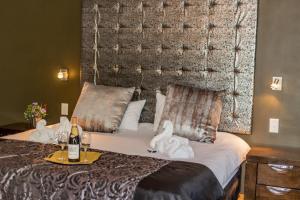 a hotel room with a bed with towels on it at Village Boutique Hotel in Otjiwarongo +72 photos