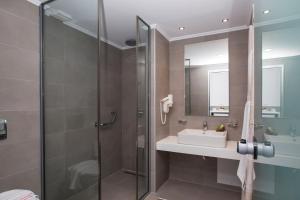 y baño con ducha y lavamanos. en Lindos Portes Suites - Adults Only, en Lindos