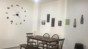 a dining room with a table and a clock on the wall at Luxury Kuala Selangor Homestay in Kuala Selangor