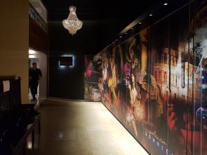 un hombre caminando por un pasillo con pinturas en las paredes en BONNIES Suites & Spa Valencia, en Valencia