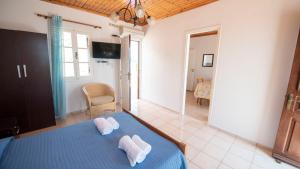 a bedroom with a blue bed with two towels on it at Filoxenia Apartments in Halki +4 photos