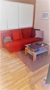 - un canapé rouge dans le salon avec une table basse dans l'établissement Alpina Inzell 335 Chiemgaukarte, à Inzell