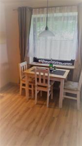 une table à manger avec deux chaises et une fenêtre dans l'établissement Alpina Inzell 335 Chiemgaukarte, à Inzell