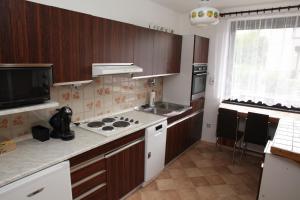 una cucina con mobili in legno e un forno a piano cottura di Dům v Českém ráji a Dolní Bousov