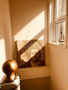 a picture of a woman on a wall next to a window at Garden Oasis in Margate