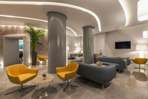 a lobby with couches and chairs in a building at Blue Lagoon City Hotel in Kos Town