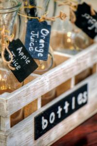 a wooden shelf with signs on it with glass jars at 23 On Glen Guest House in Port Elizabeth