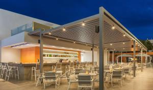 a restaurant with tables and chairs and a bar at Blue Lagoon City Hotel in Kos Town