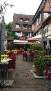 een patio met tafels en stoelen en een gebouw bij Chambres touristiques La Cour Des Hôtes in Obernai