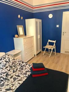 a bedroom with blue walls and a bed and a chair at Kwatera Prywatna Marini in Sopot