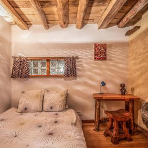 1 dormitorio con cama y mesa de madera en The Dragon Barn - Studio en Ascou