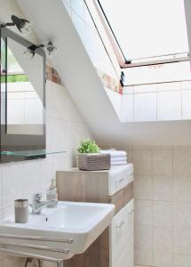 a bathroom with a sink and a skylight at Haus am Donausee (House at the Danube Lake Beach) in Weitenegg