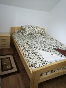 Una cama con un edredón blanco y negro. en Pensiunea ,,Suciu", en Răchiţele