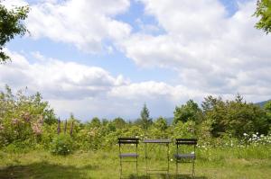 dos sillas sentadas en medio de un campo en Haiji, en Shizukuishi