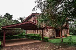 een stenen huis met een paviljoen ervoor bij Oilepo Cottage in Naivasha