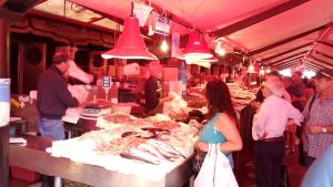a group of people standing around a market with food at Villa Delux in Correzzola